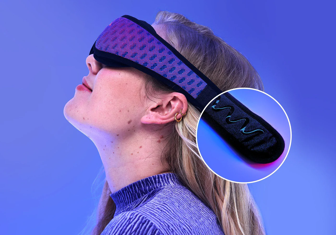 Side view of a blonde girl’s head, wearing a blue mesh sleep mask. A round circle magnifies the grippy gel on the head strap.