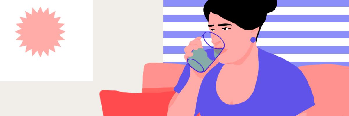 A woman sitting on her bed drinking a glass of water early in the morning.