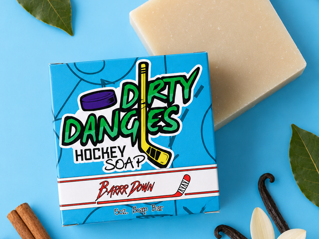 Barrr down bay rum scented hockey soap bar on a blue background with cinnamon, vanilla and bay leaves.
