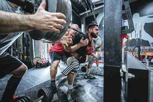 man lifting weights barbell squat pr