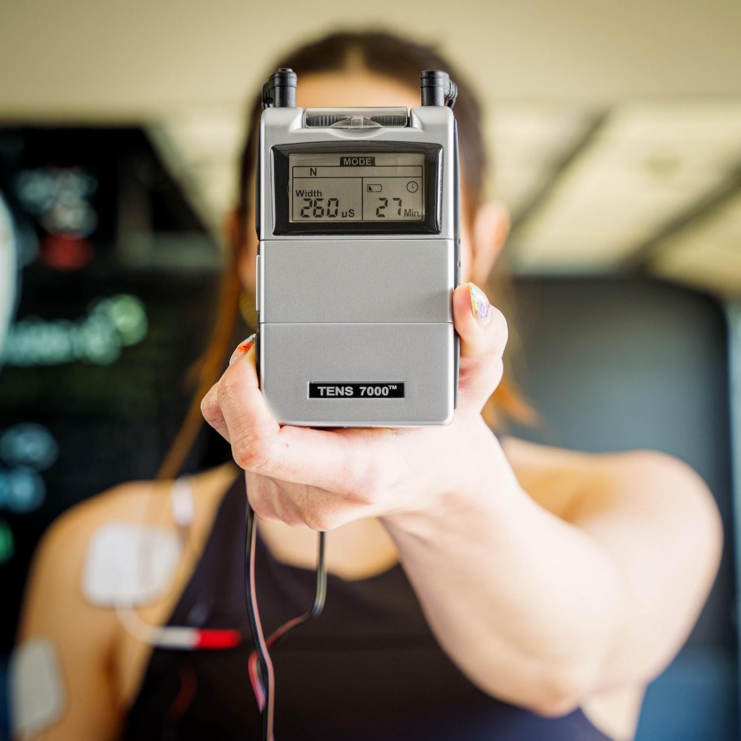 A TENS unit being held up to the camera