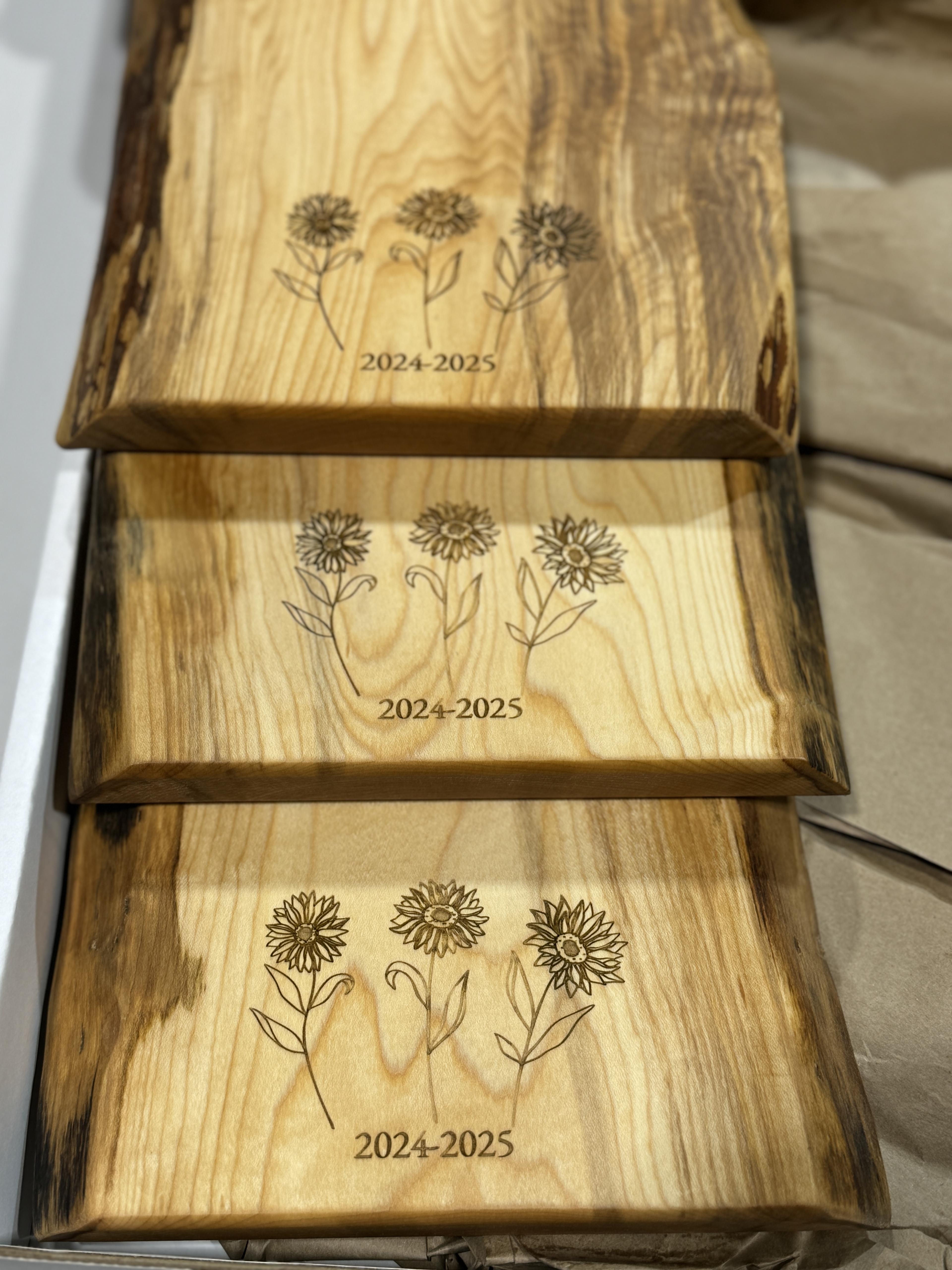 maple live edge charcuterie boards as heartfelt year end gifts for her children’s teachers with three sunflowers, a symbol of joy and appreciation, along with the year.