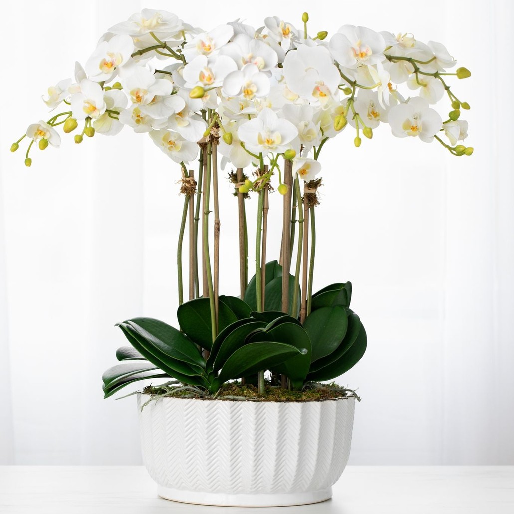Faux orchid centerpiece arrangement in white vase