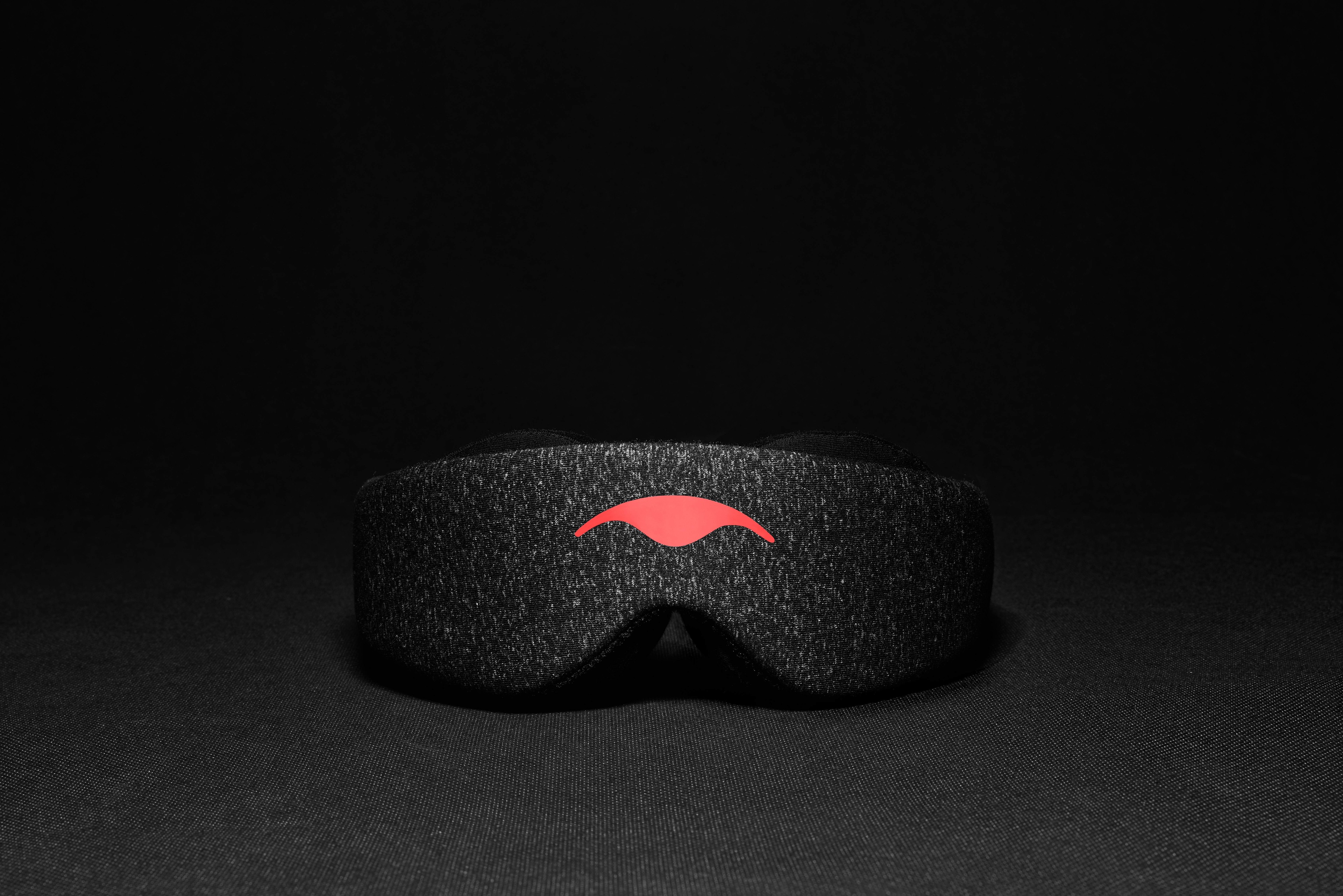 A black sleep mask with eye cups against a black background.