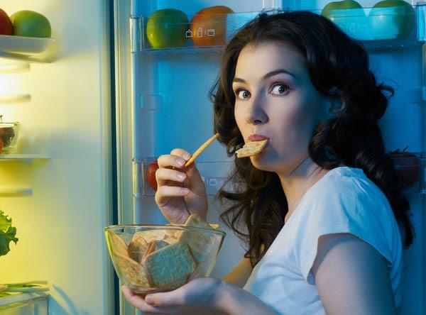 Woman Eating Food From Fridge Looking at Camera Surprised