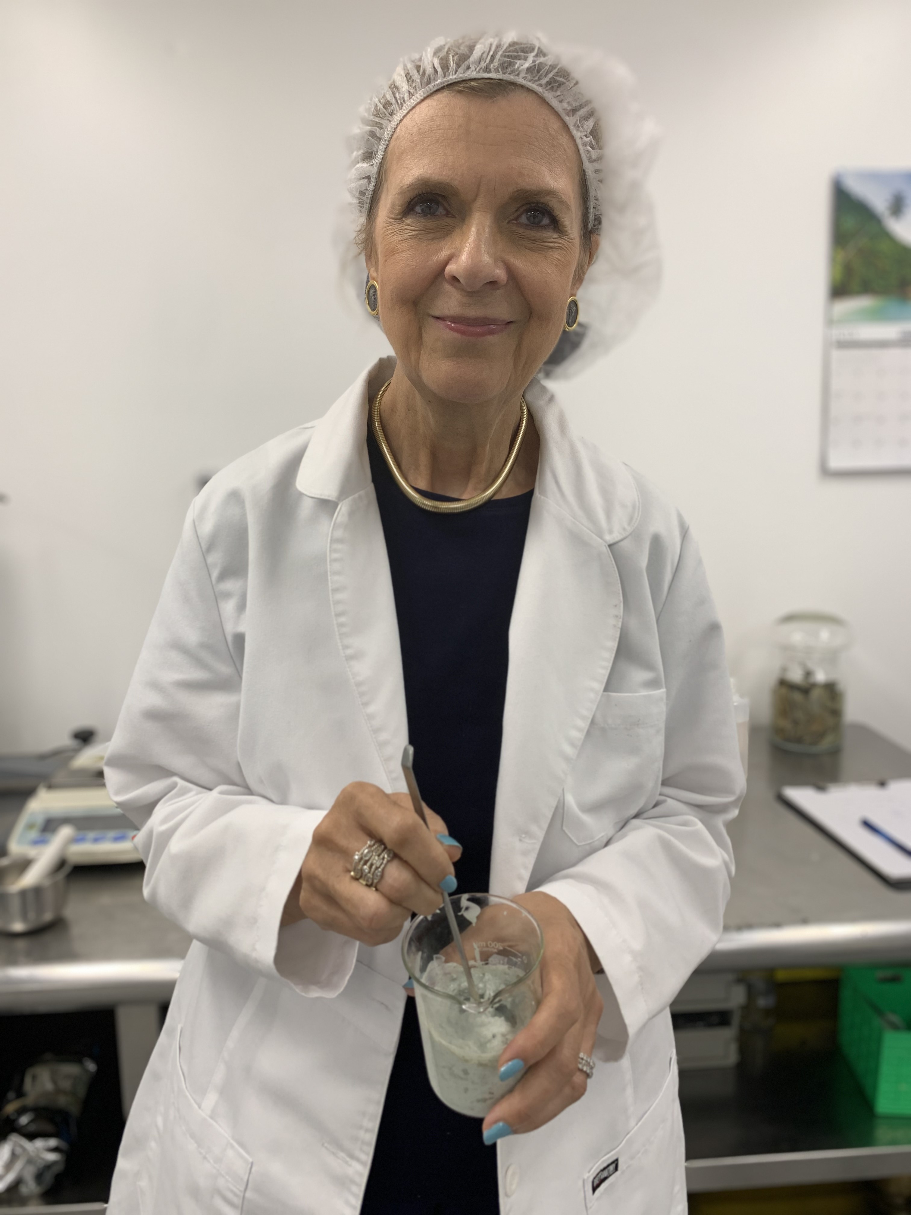 Marina Valmy holding all natural ingredients as she formulates products in our lab