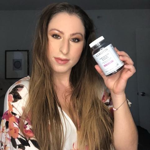 Model With Long Gray Hair Holding a Bottle of Kerotin Hair Vitamin Gummies