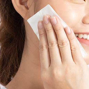 women dabbing her face with tissue