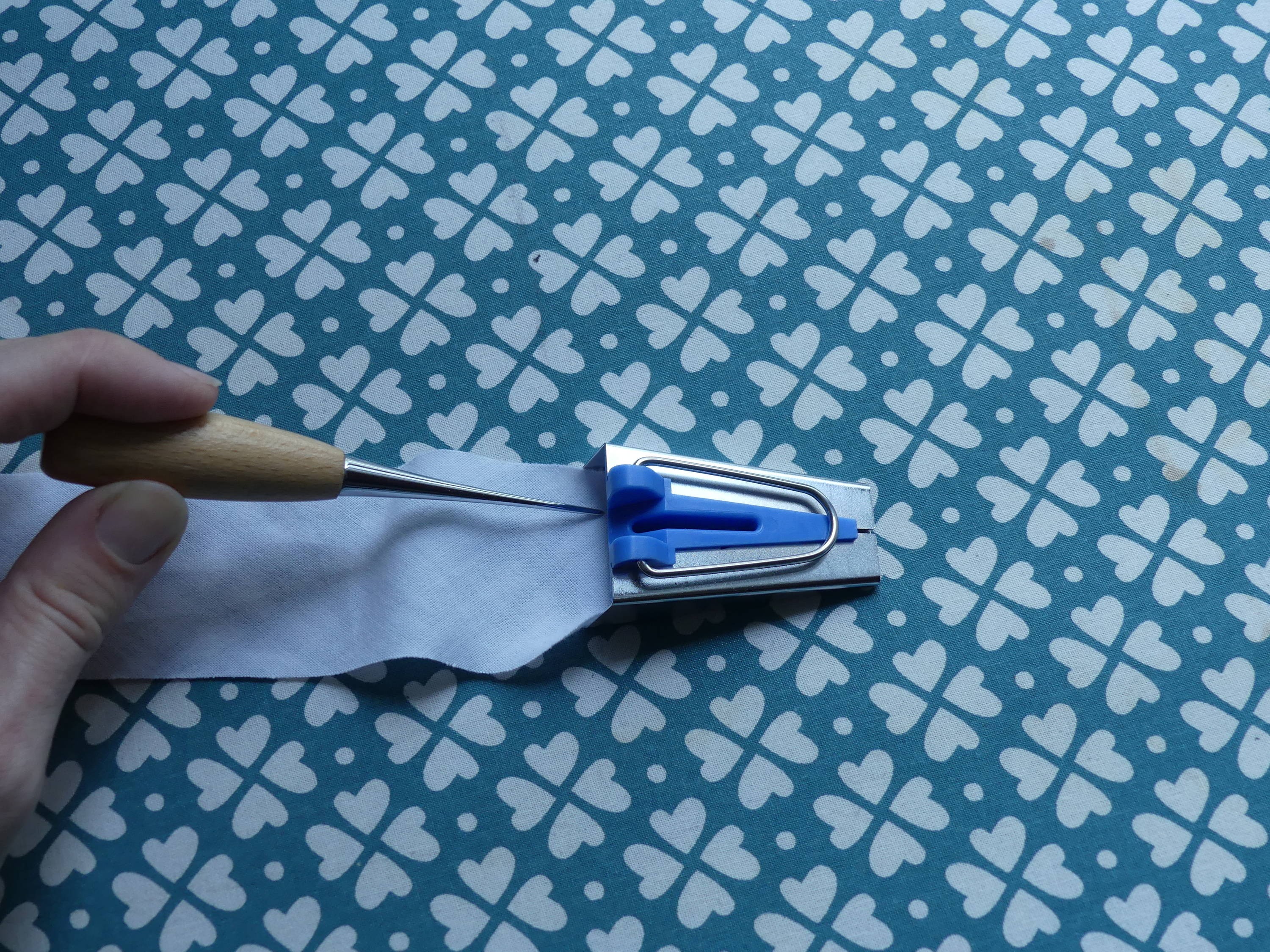 Using an Awl to push the fabric through the Bias Tape Maker