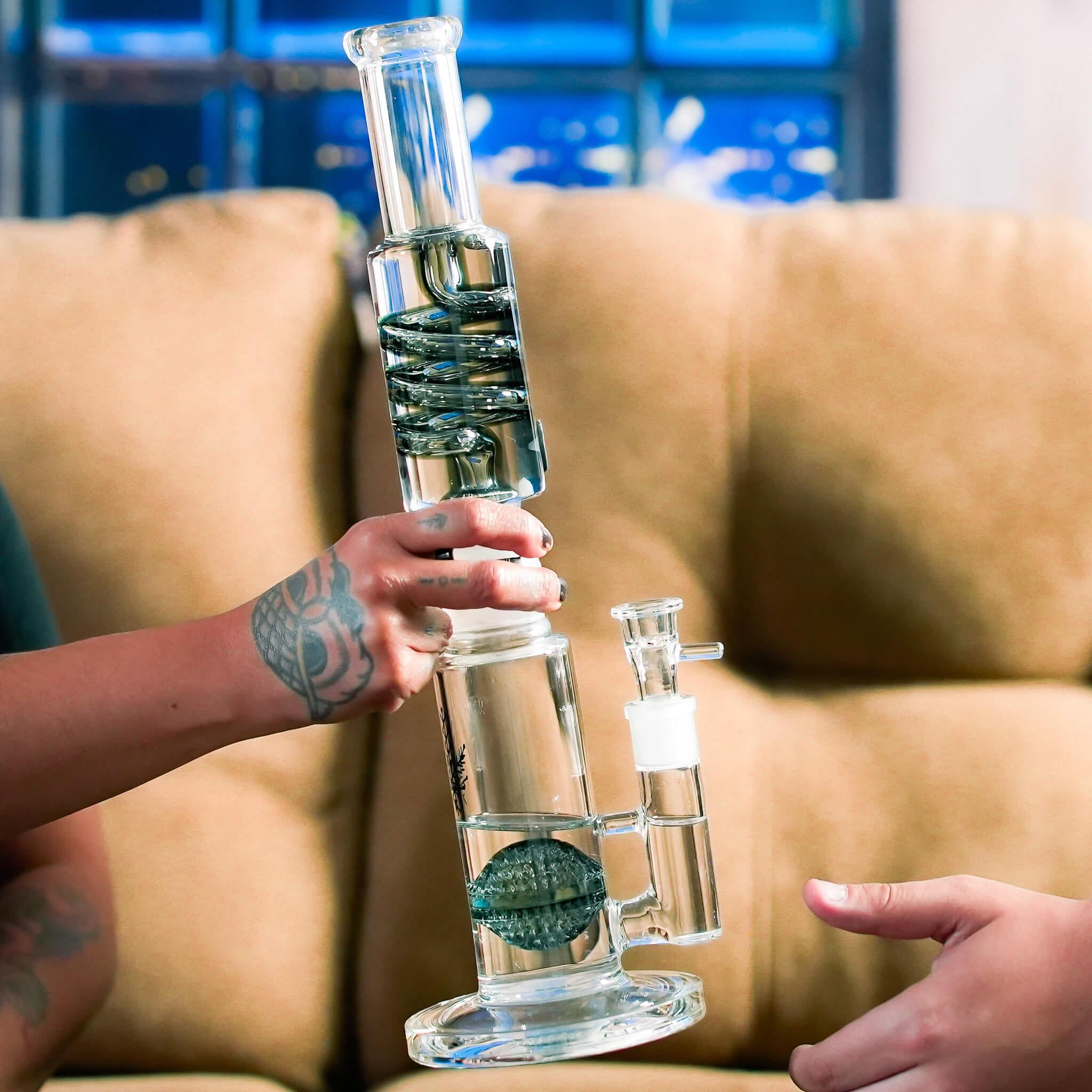 hands passing glass inside out bong