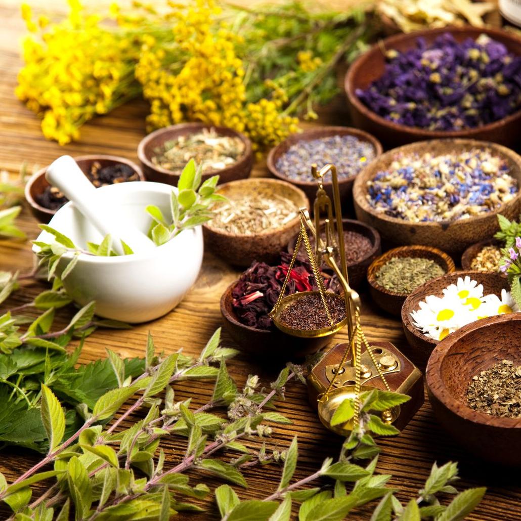 a variety of different size wooden bowls with various herbs in them