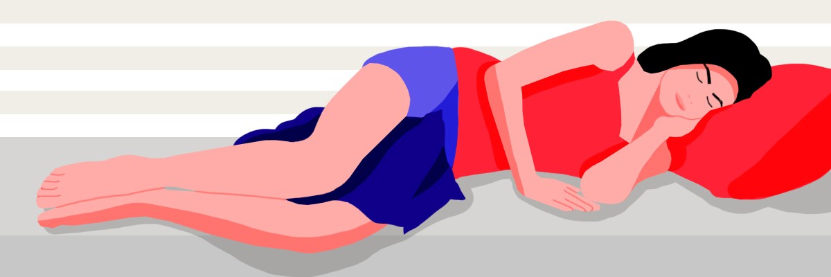 A girl lying down on her left side in the best sleeping position for asthma with a pillow between her legs.