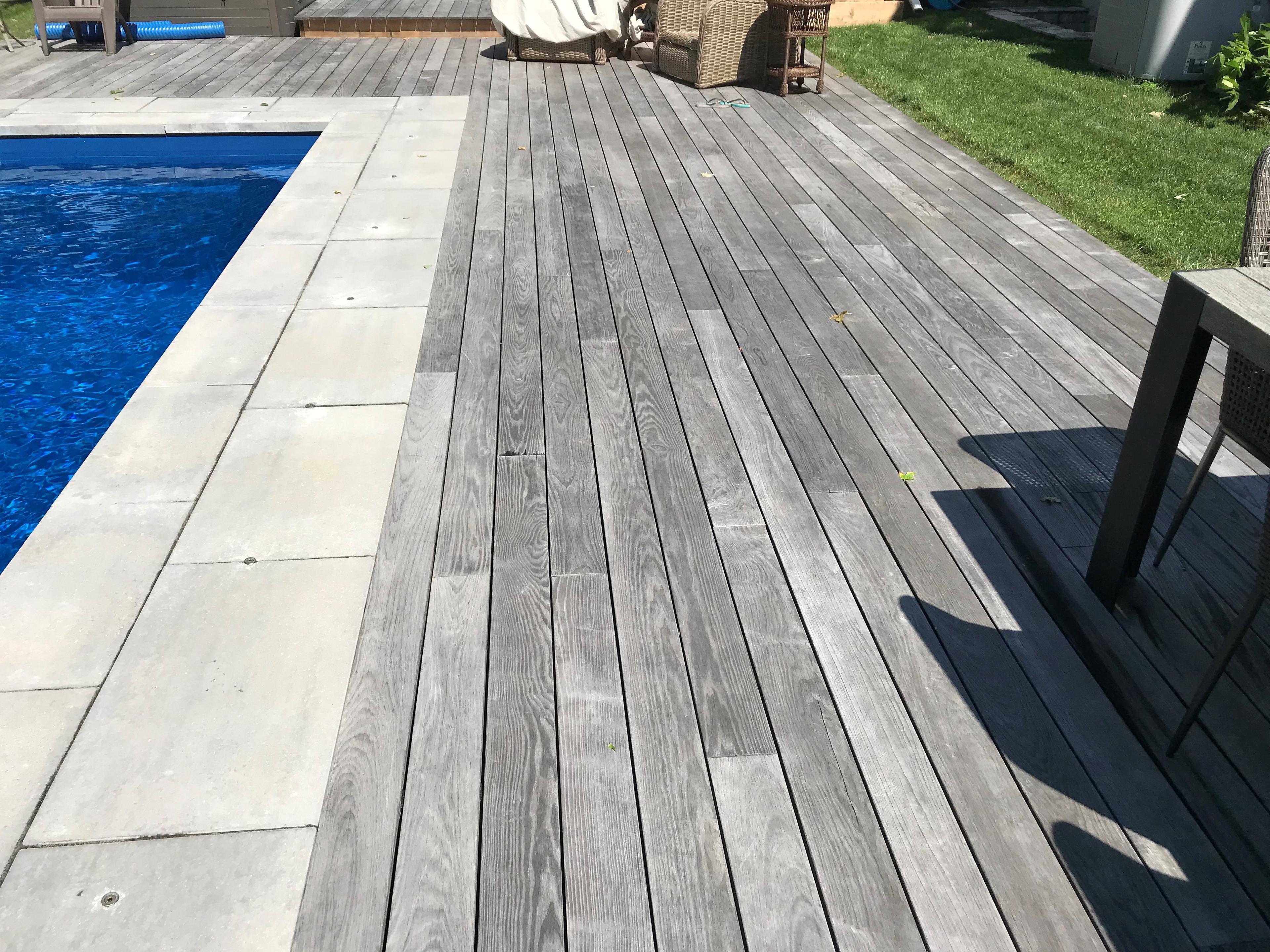 close up of rustic grey deck boards surrounding a pool