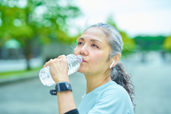 Senior woman drinking out of a water bottle.