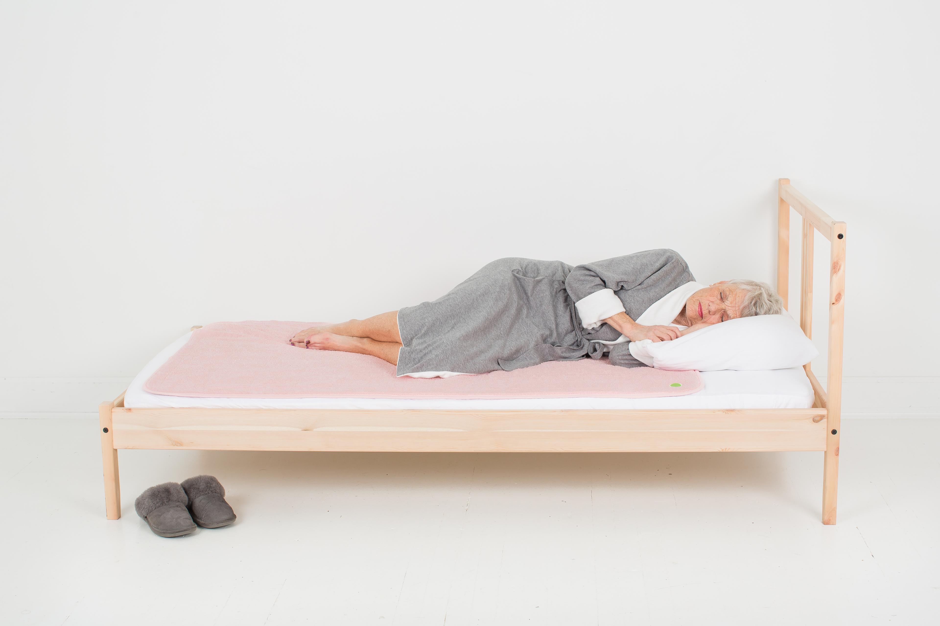 elderly woman sleeping on large pink PeapodMat