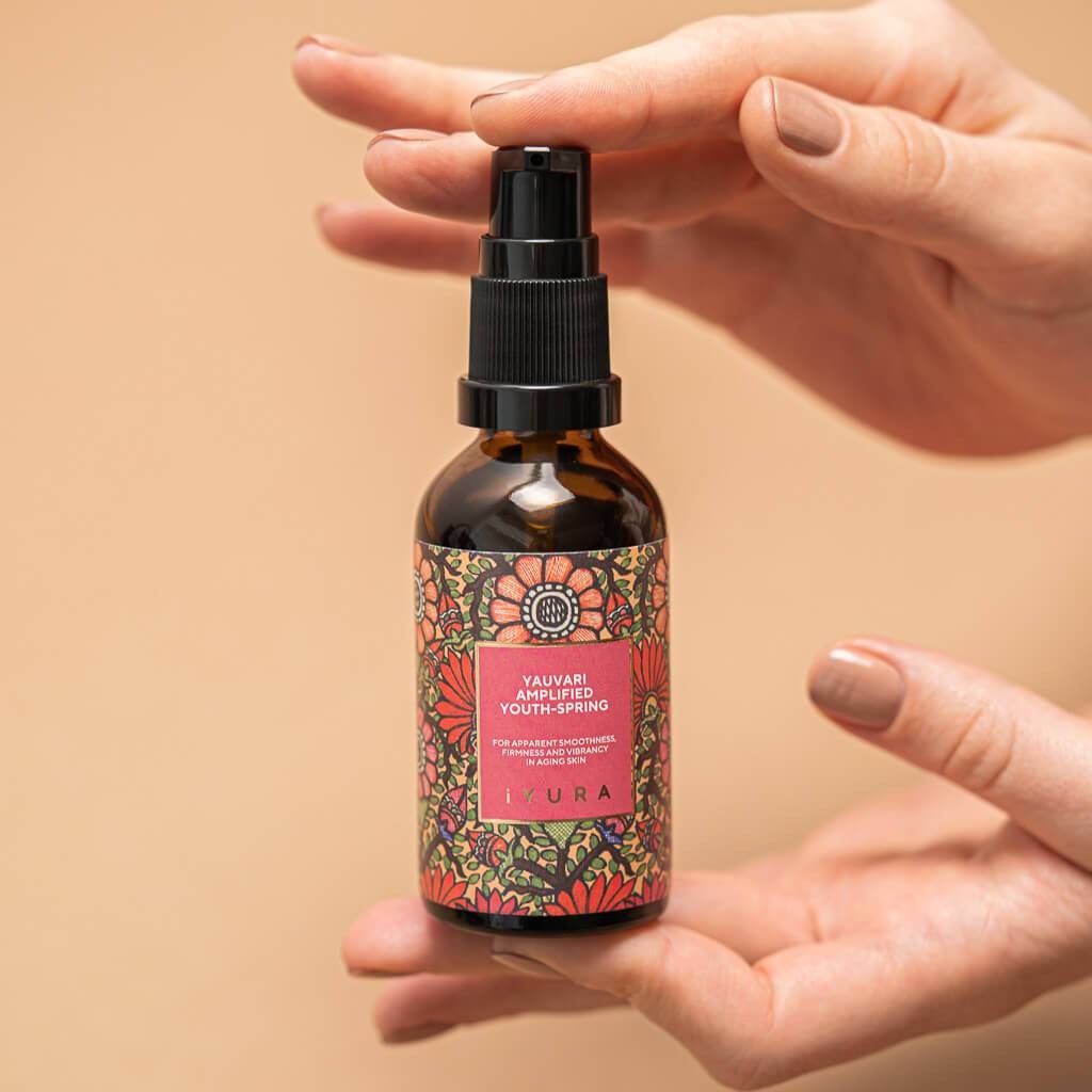 woman's hands presenting yauvari amplified youth spring bottle