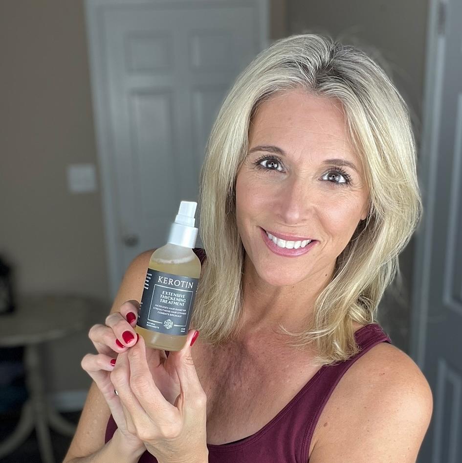 Model With Dark Hair Holding a bottle of Kerotin Hair Vitamins