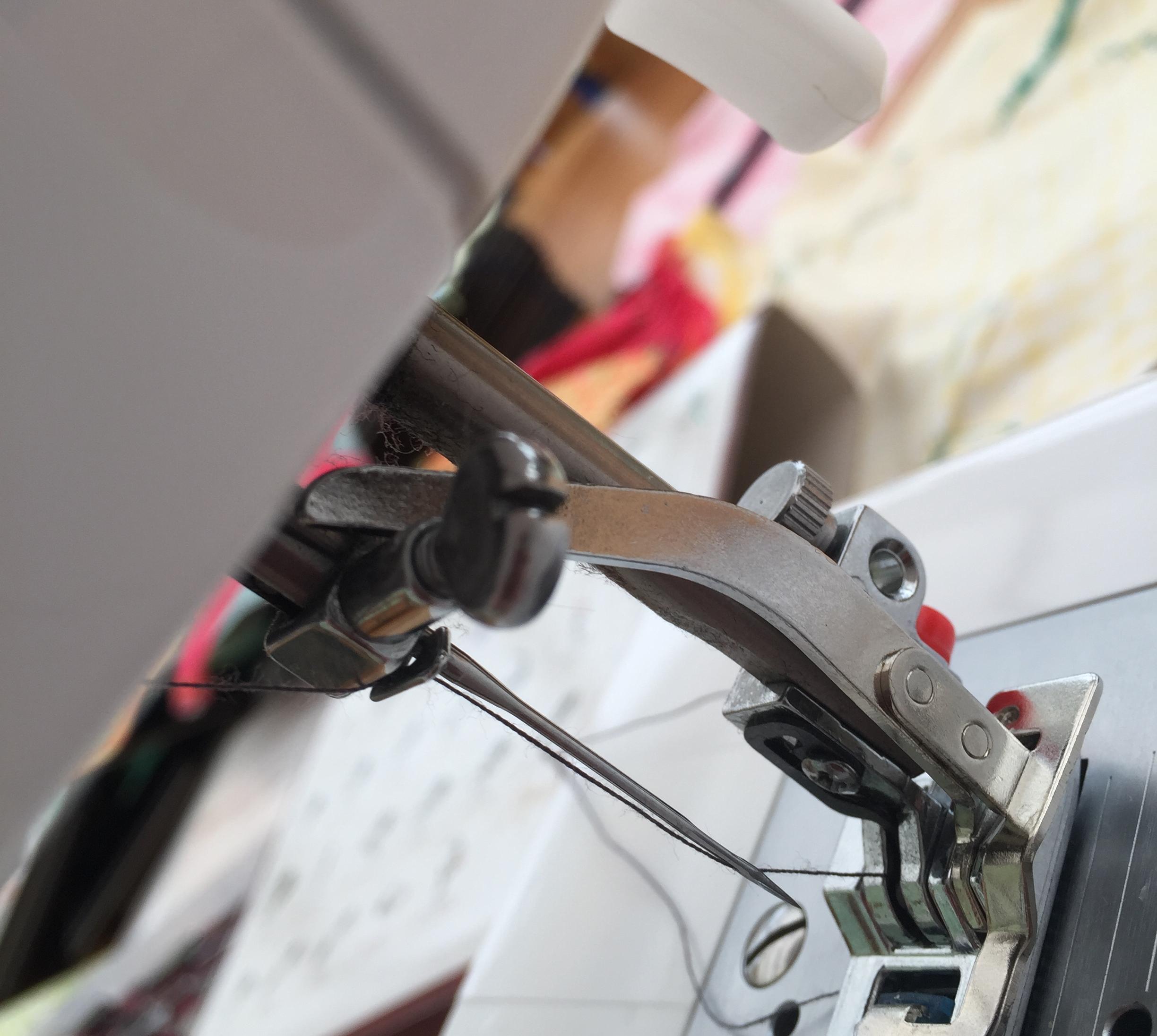 detail of the knit foot arm that sits above the needle bar of the sewing machine