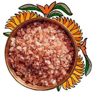 A bowl of Himalayan rock salt surrounded by floral artworks