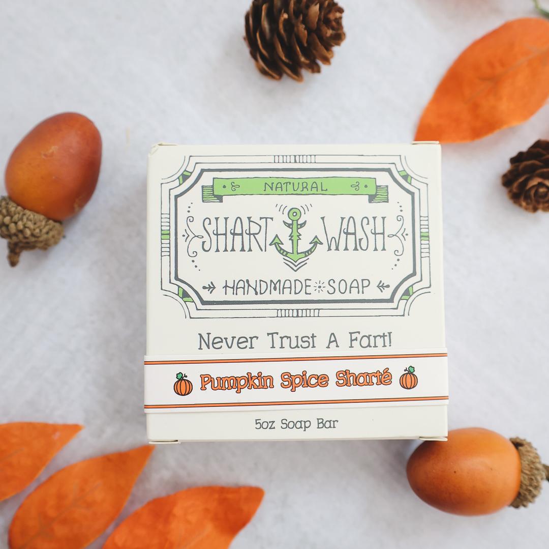 Picture of a box of Shart Wash Natural Handmade Bar Soap Lavender Lemongrass scent sitting on a purple and white bar of soap with a wood background