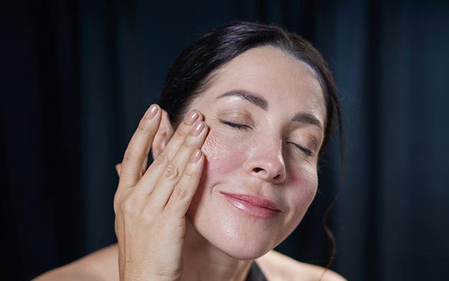 Image showing a woman applying on her face