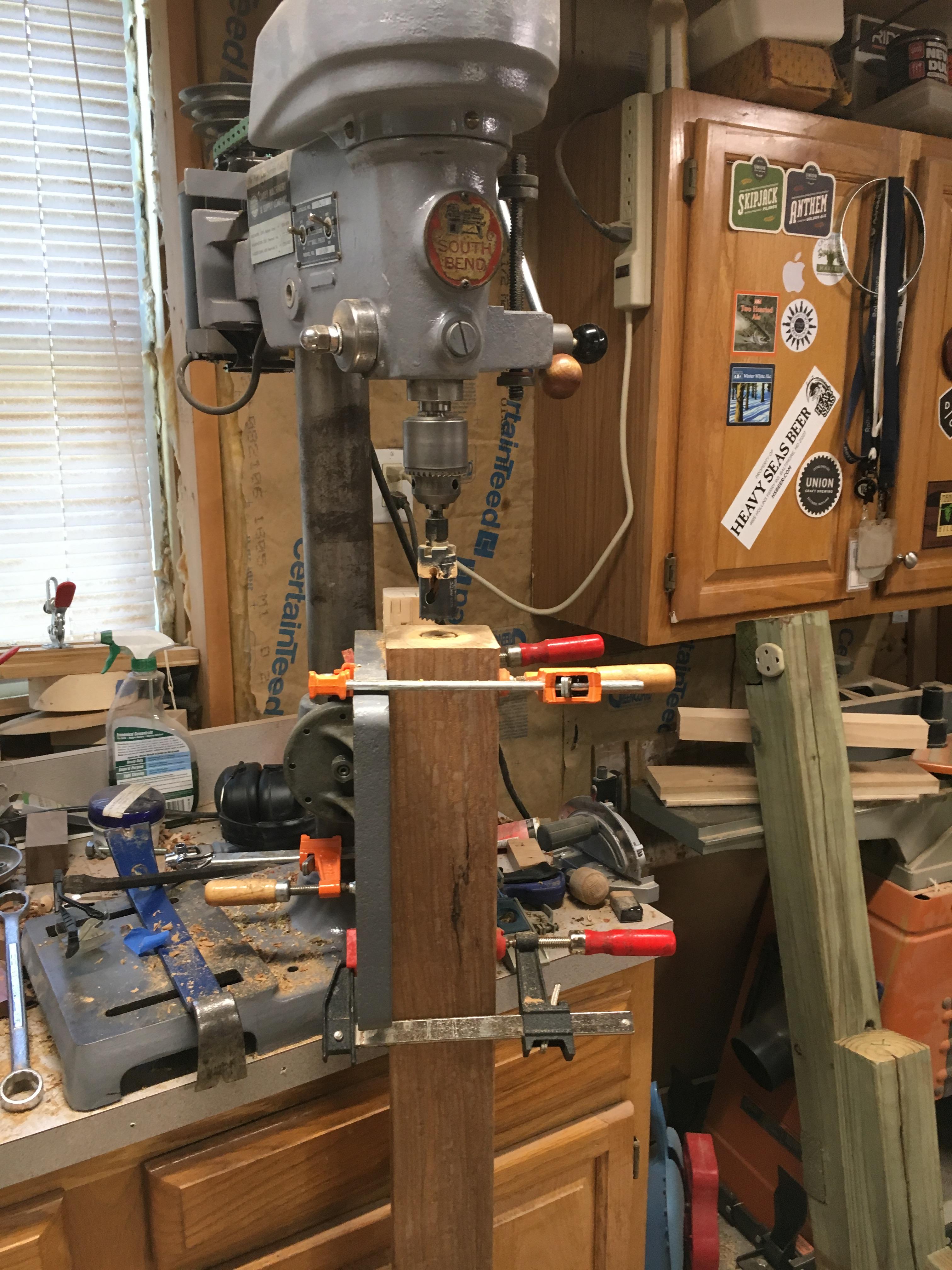 A drill press with a hole saw attachment