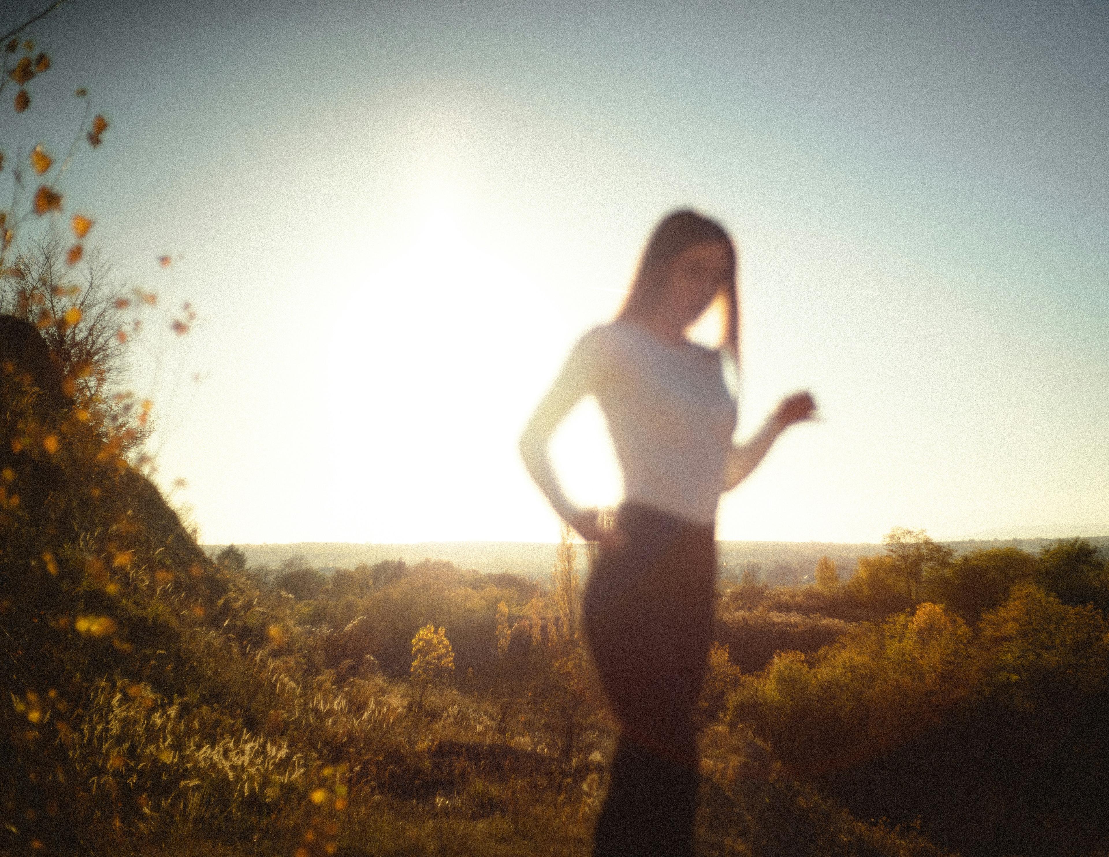 A woman taking a 30 minute walk to receive unfiltered sunlight to increase vitamin D production.