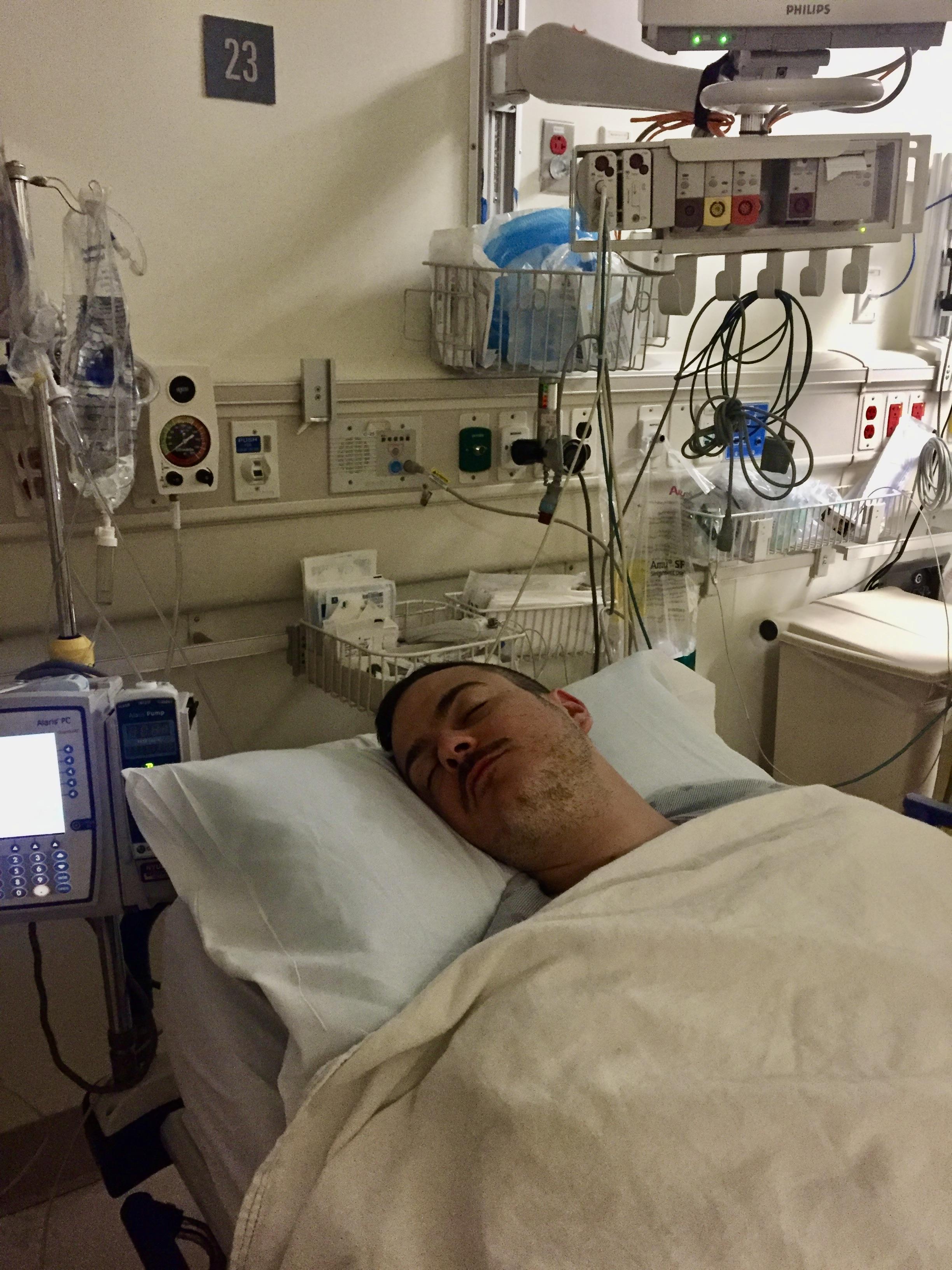 Joseph Quartana in a hospital bed at NYU Langone post life-saving surgery, hours after accepting the Fragrance Foundation Perfume Extraordinaire blindjudged award.
