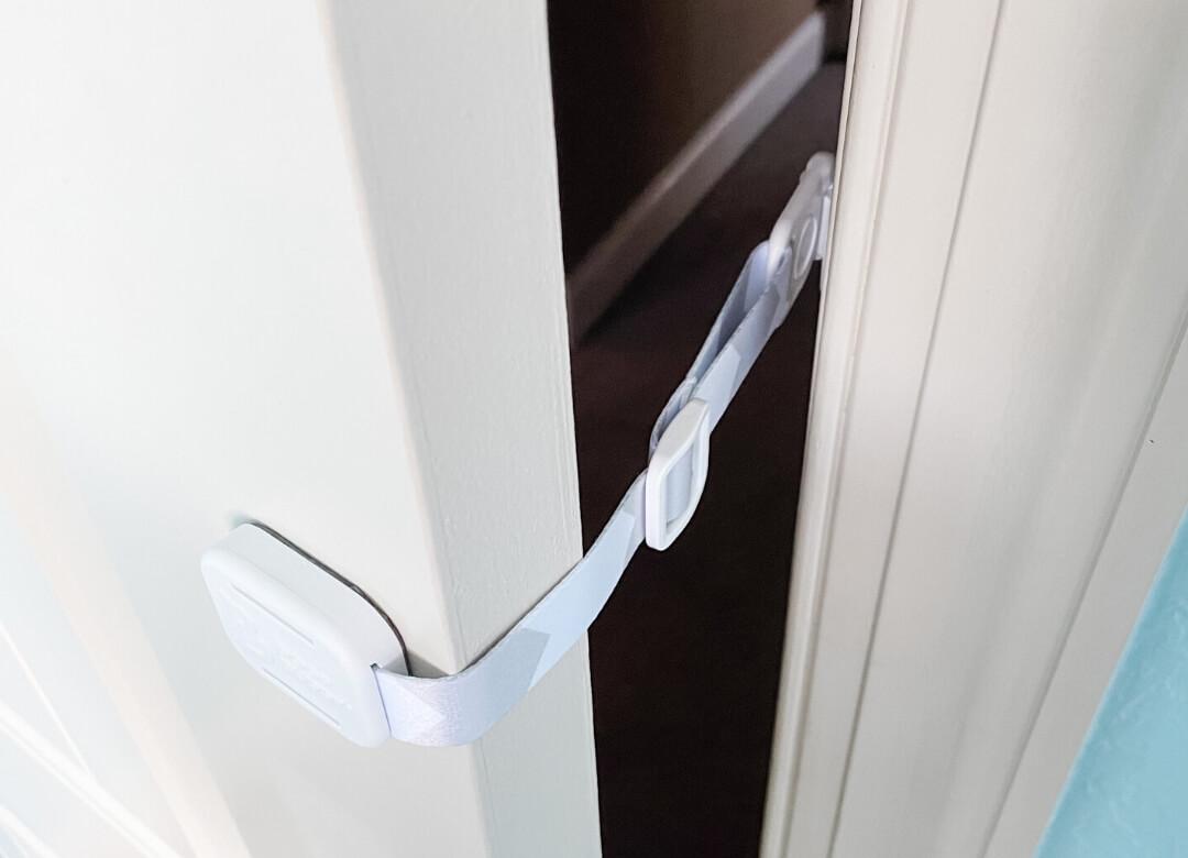 Side view of Door Buddy door strap mounted inside the door frame with the strap angled to limit how far the door opens.