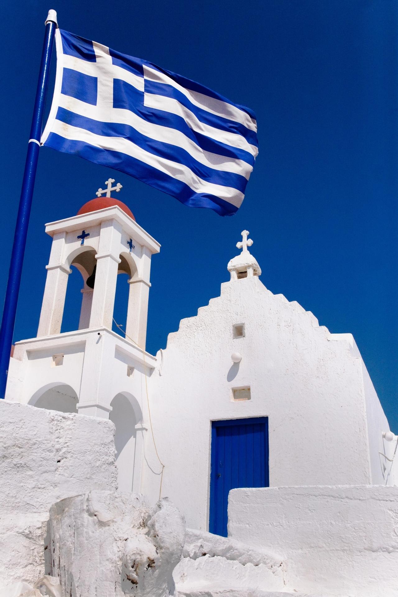 A traditional small Orthodox church with the Greek flag