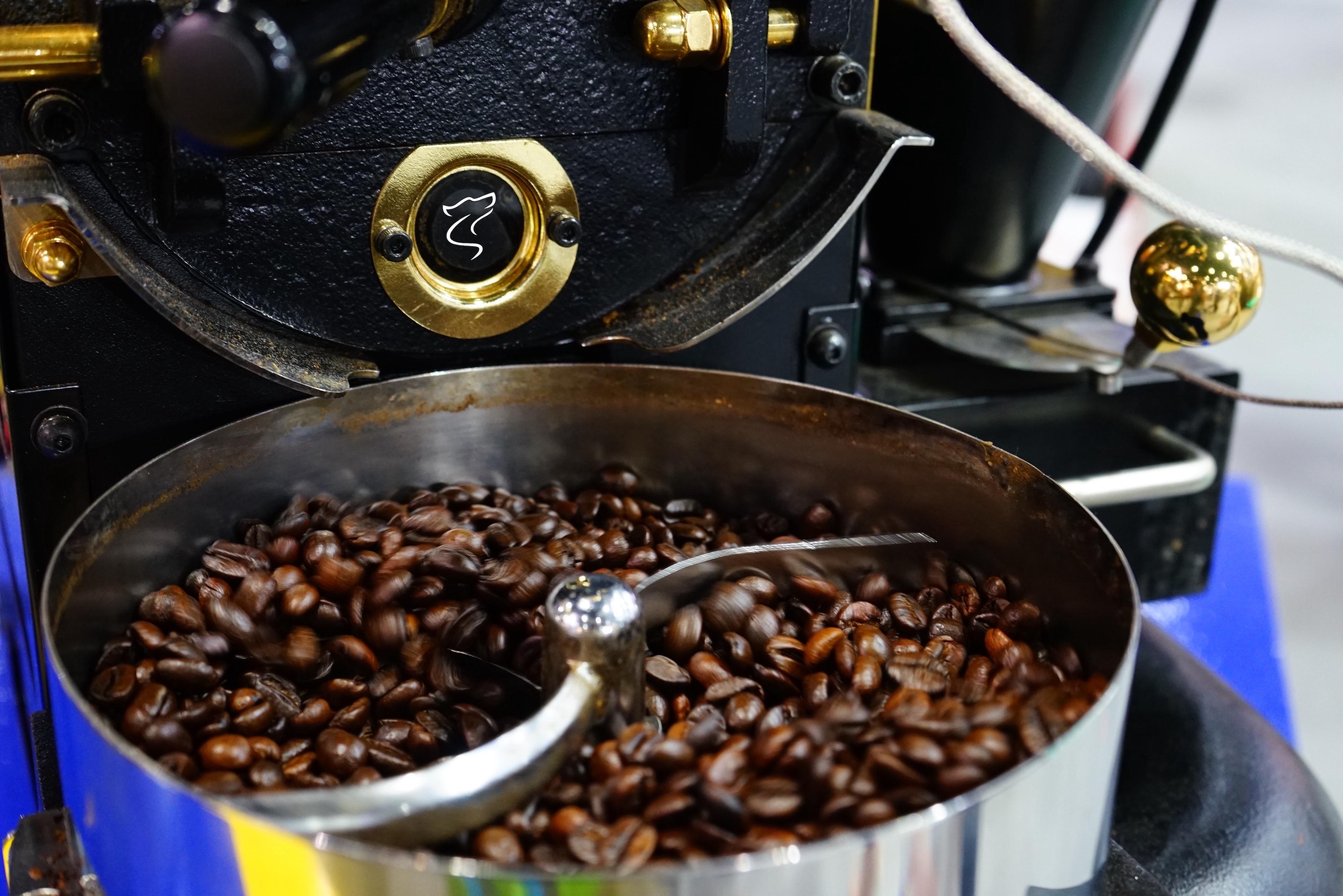 Close-up of freshly roasted coffee beans cooling in a small-batch roaster drum at Lone Wolf Coffee Co., showcasing handcrafted roasting process and premium specialty-grade quality.