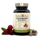Bottle of Herbal Roots Cranberry with Nettle with capsules on the right and three fresh cranberries on the left of the bottle