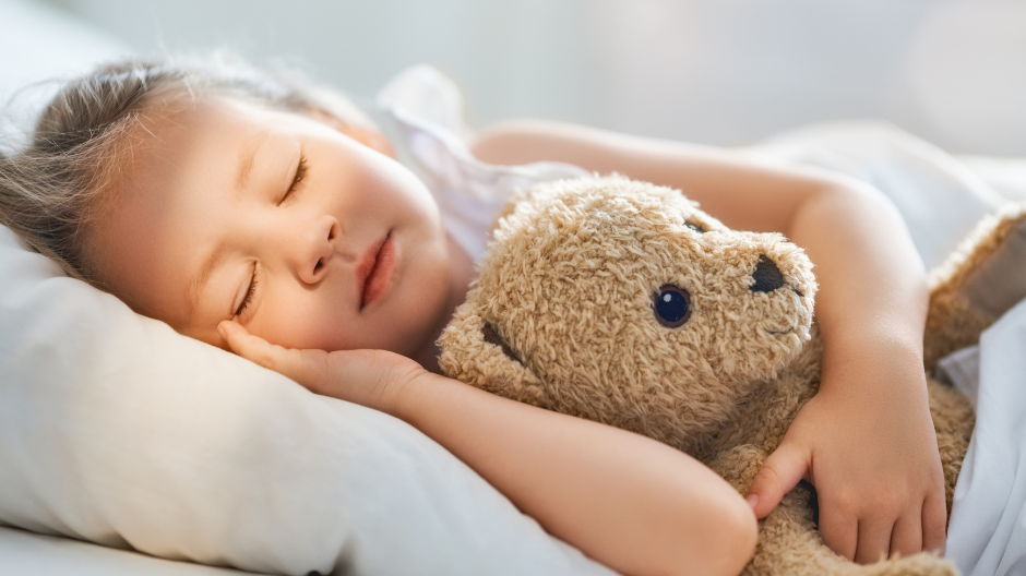 girl sleeping with a teddy bear