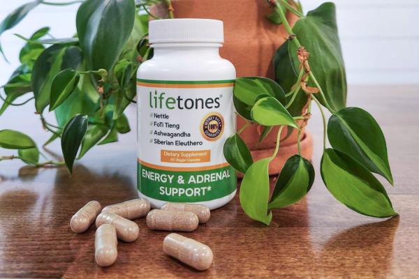 Energy & Adrenal Support Capsules on table with plant.