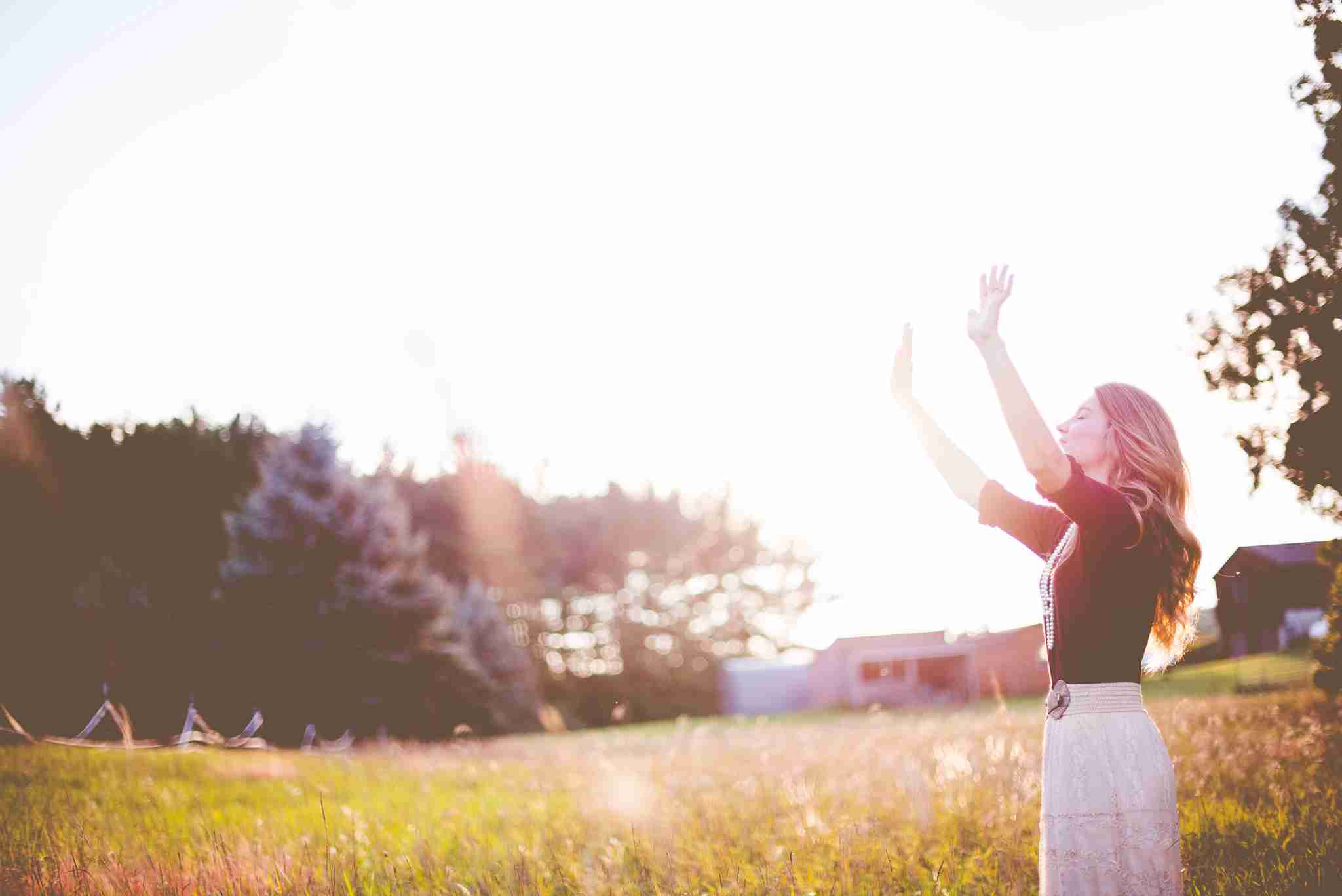 Woman Holding Hands Up in a Field