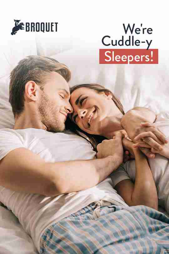 couple smiling while cuddling in bed, broquet logo, text reads: We're cuddle-y sleepers!