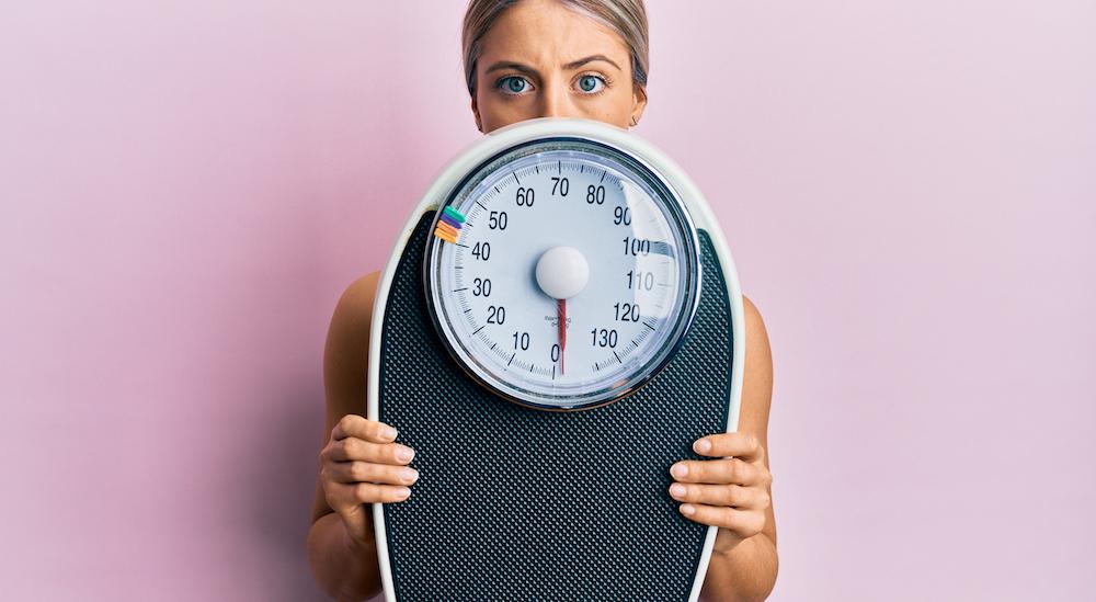 woman holding weight scale