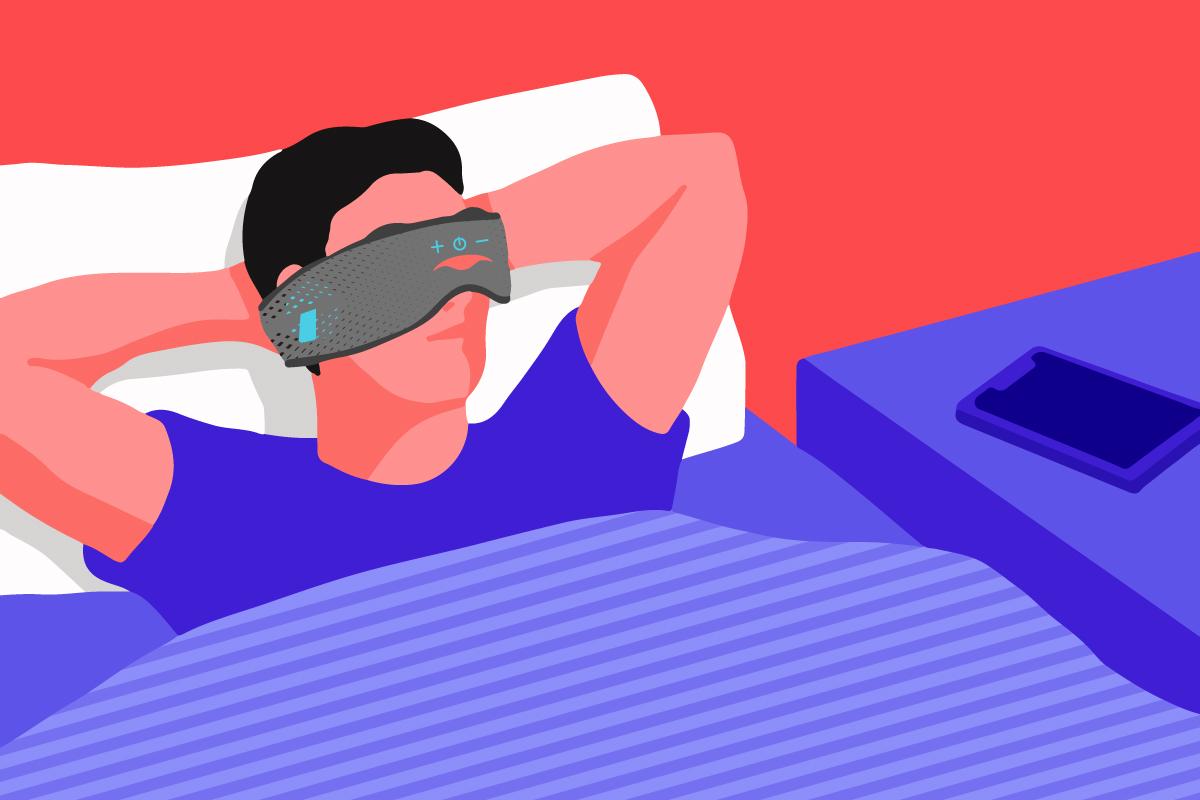 A man relaxing on a bed, wearing a Bluetooth® sleep mask.