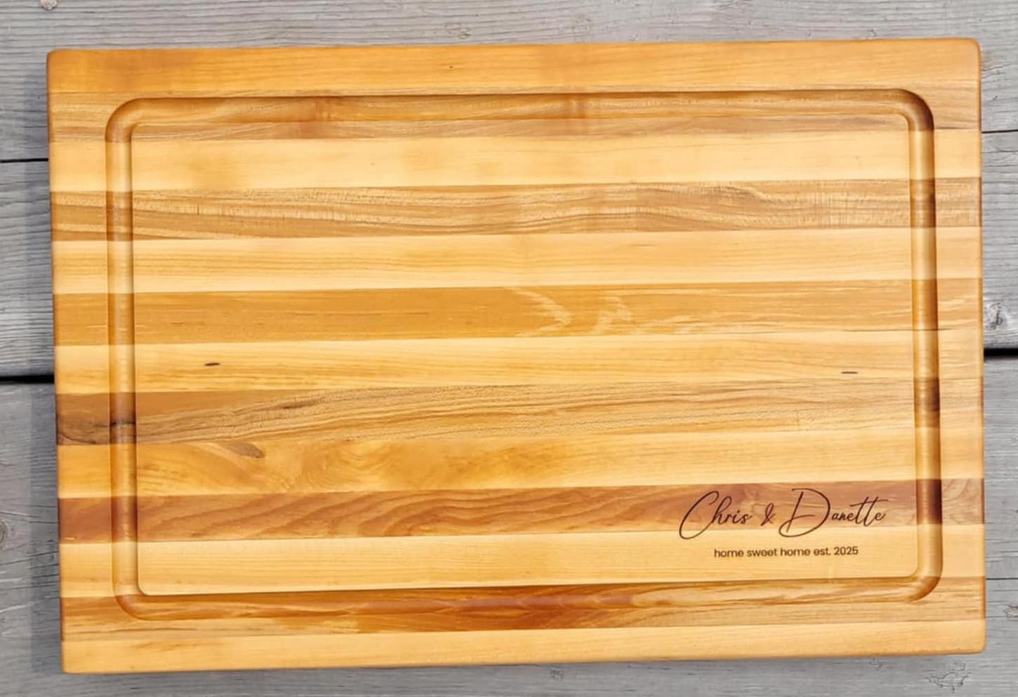 Personalized edge grain hardwood cutting board with juice groove and engraved logo, shown from above