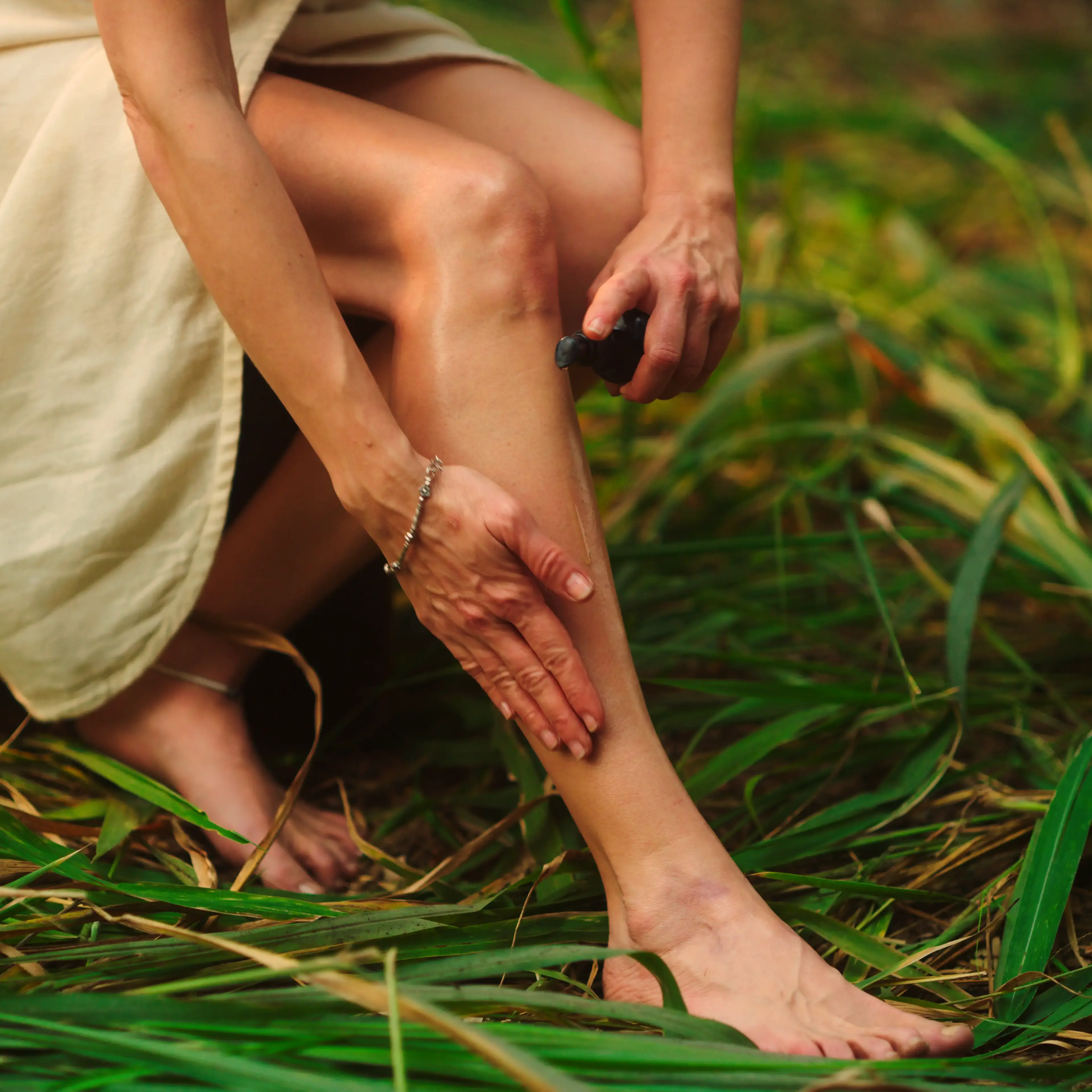 An image of a women in calming forest setting applying Balaayah to their legs