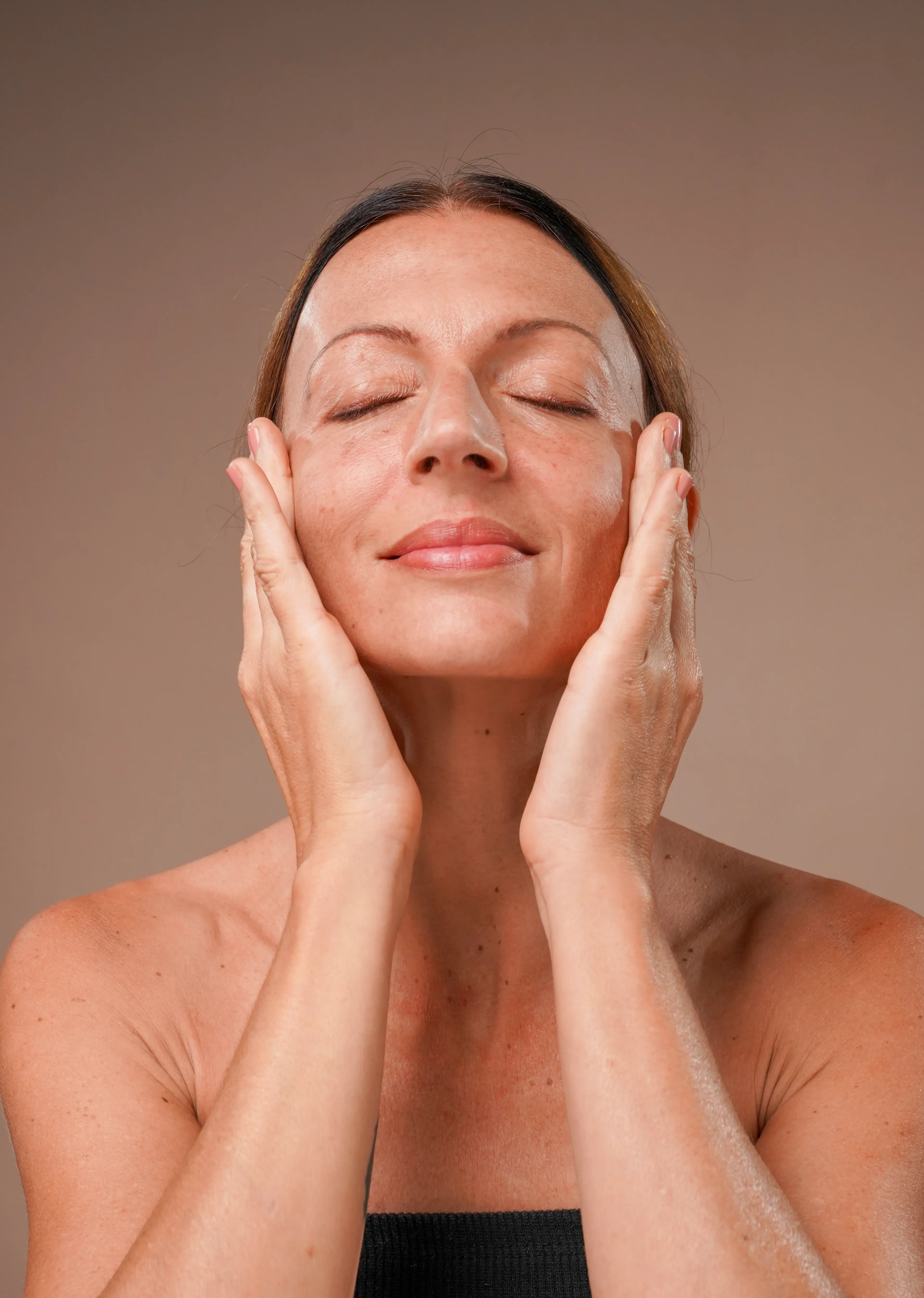woman massaging her face and feeling relaxed
