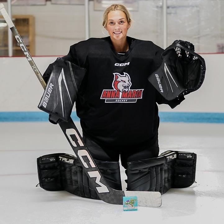 Women’s hockey goalie on the ice with Dirty Dangles hockey soap in front of the net.