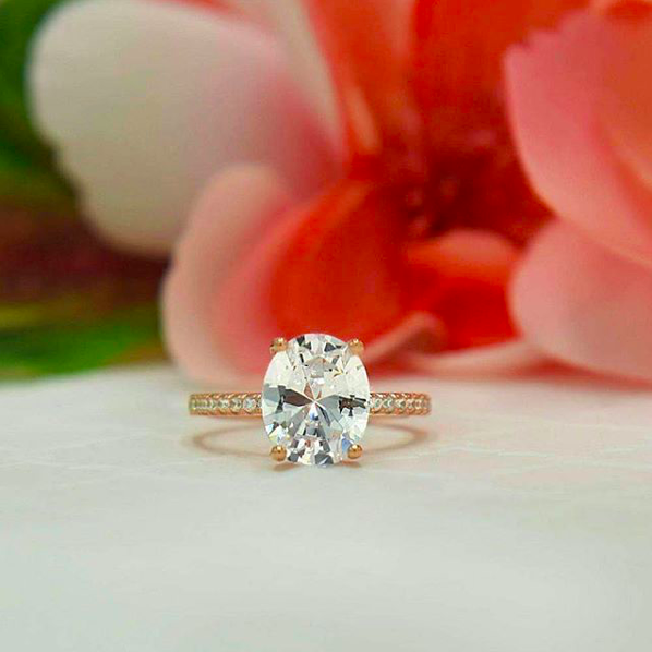 Blush and Bar ring in front of flowers