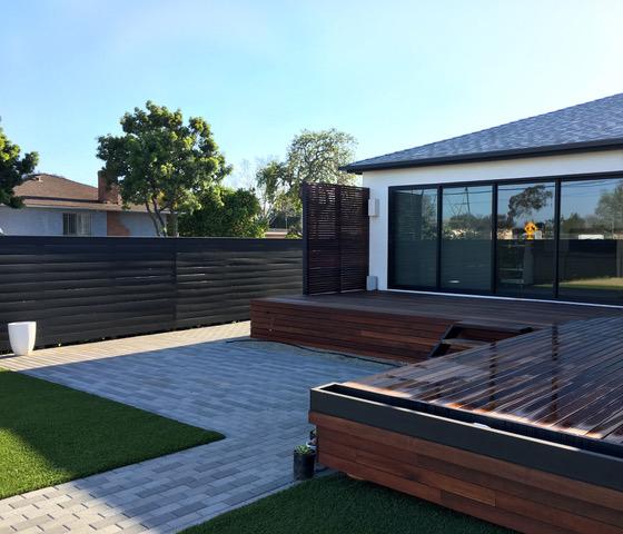 medium shot of Brian's deck and privacy panel with palm tress and blue skies in the background