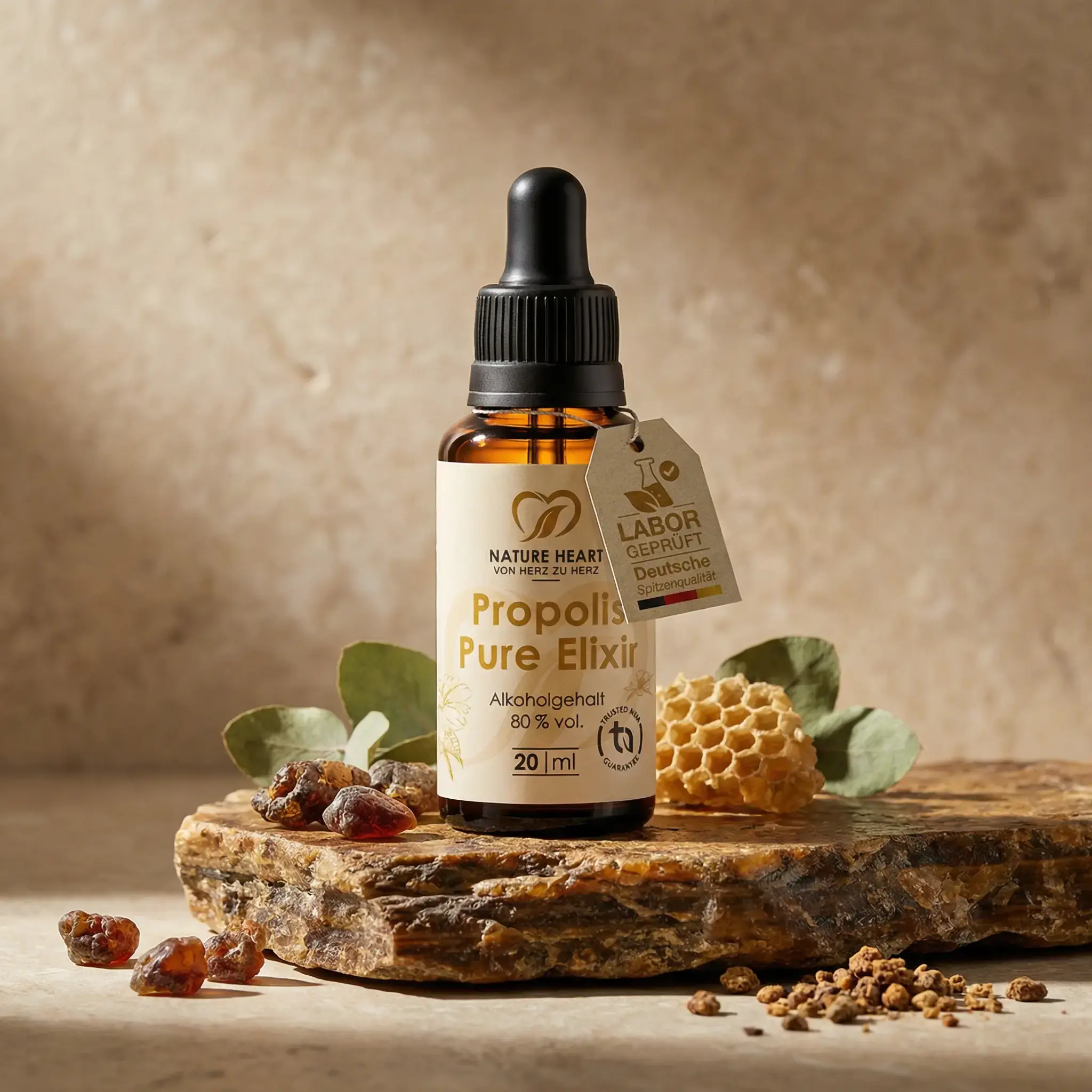 Nature Heart Propolis Pure Elixir 20 ml mit 80 % Alkoholgehalt auf Stein mit Propolis-Stücken, Honigwabe und Eukalyptusblättern