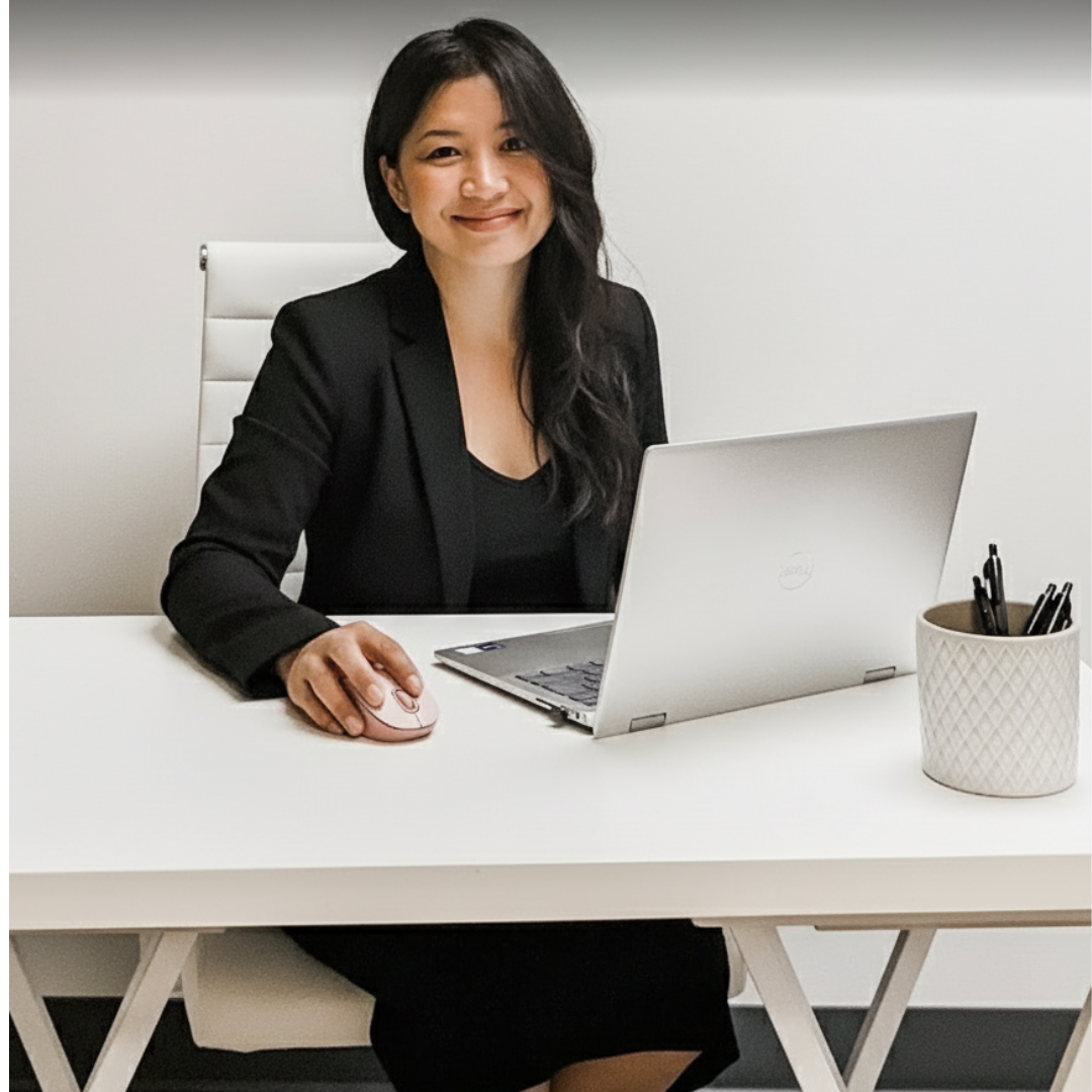 Tina Somsith, sitting behind a desk and working