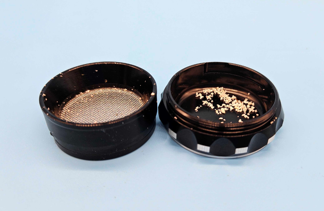 Close-up of the kief collection chamber and durable micron-mesh screen of a Prism 4-piece herb grinder, featuring a wider mesh design for superior kief collection and long-term durability.