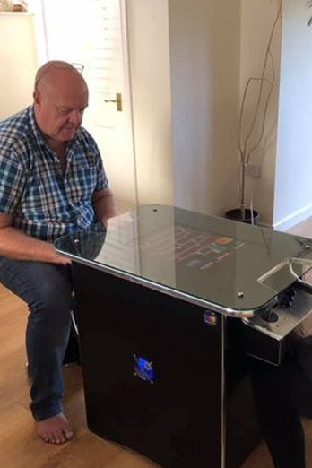 Black and chrome retro cocktail table arcade machine with customer playing