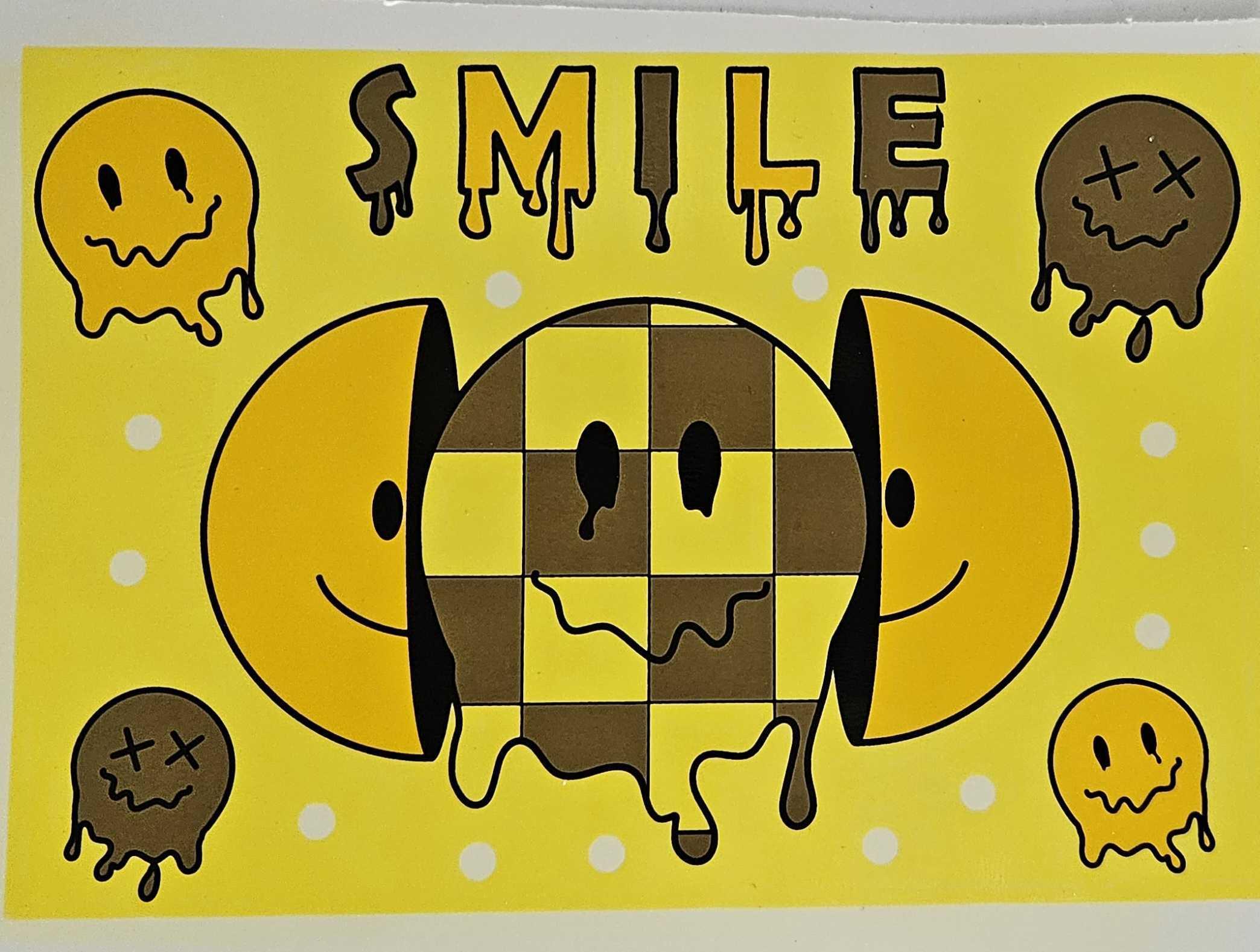 A raw, unfired decal sheet for the Prism Smile Collection featuring yellow drippy smiley faces and purple checkered patterns. The image illustrates the pre-application stage of the modular glass decorating process, showing the intricate detail of the handcrafted artwork before it is heat-sealed onto the bong bases and mouthpieces.