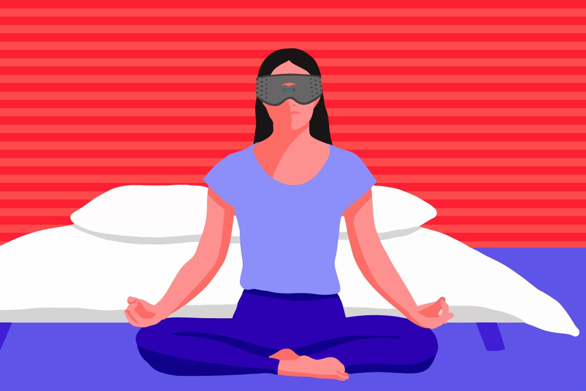 A girl sitting down in the Lotus position in front of her bed, wearing the best meditation eye mask.